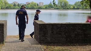 zdjęcie przedstawia policjantka i strażnik miejski rozmawiający z mieszkanką