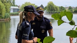 zdjęcie przedstawia policjantka i strażnik miejski rozmawiających z mieszkańcem