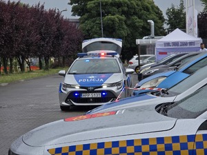 zdjęcie przedstawia radiowóz z włączonymi sygnałami