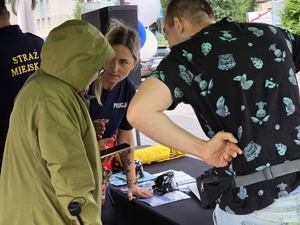 zdjęcie przedstawia policjantkę rozmawiającą z mieszkańcami