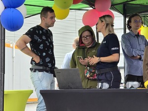 zdjęcie przedstawia policjantkę rozmawiającą z mieszkańcami
