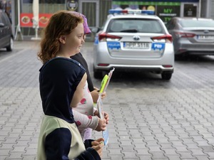 zdjęcie przedstawia dzieci a w tle radiowóz