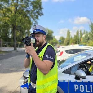 zdjęcie przedstawia: policjanta mierzącego prędkość