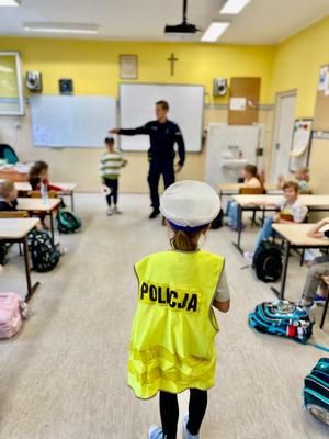 zdjęcie przedstawia: policjanta rozmawiającego z dziećmi w szkole