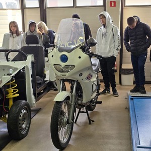 zdjęcie przedstawia grupę uczniów i motocykl policyjny