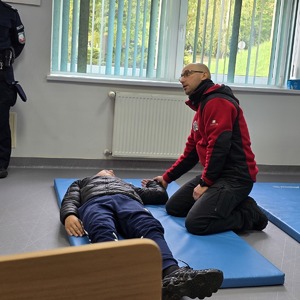 zdjęcie przedstawia policjanta prowadzącego szkolenie z pierwszej pomocy