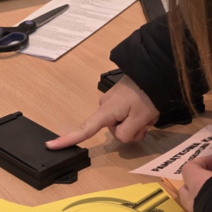 zdjęcie przedstawia uczniów pobierających odciski palców