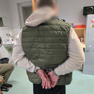 zdjęcie przedstawia mężczyznę w kajdankach