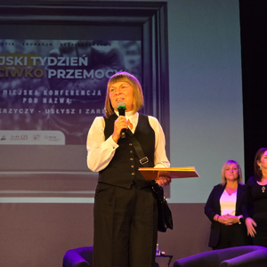 zdjęcie przedstawia kobietę przemawiającą do mikrofonu