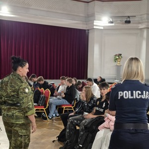zdjęcie przedstawia policjantkę i funkcjonariuszkę straży granicznej rozmawiającą z młodzieżą