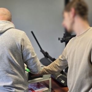 zdjęcie przedstawia technika kryminalistyki który pobiera odciski palców mężczyźnie