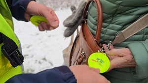 zdjęcie przedstawia policjanta rozdającego odblaski