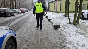 zdjęcie przedstawia policjanta rozdającego odblaski