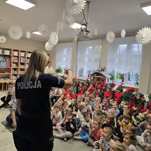 zdjęcie przedstawia policjantkę rozmawiającą z dziećmi