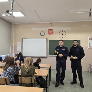 zdjęcie przedstawia policjanta i strażnika miejskiego podczas prelekcji w szkole