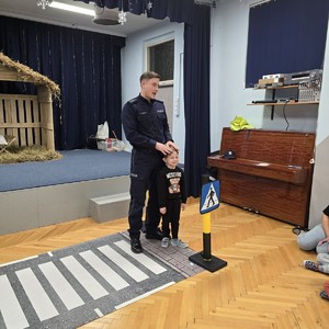 zdjęcie przedstawia policjanta i chłopca podczas prelekcji
