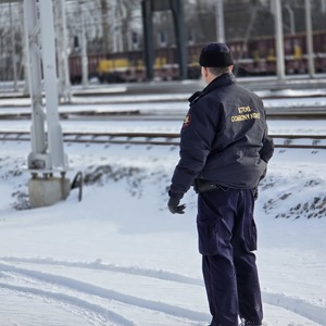 zdjęcie przedstawia funkcjonariusza straży ochrony kolei podczas patrolu na torowisku
