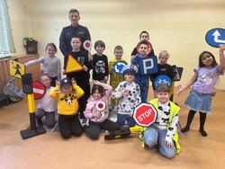 zdjęcie przedstawia policjanta rozmawiającego z dziećmi w szkole