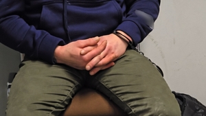 zdjęcie przedstawia mężczyznę z założonymi kajdankami