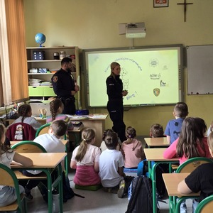 zdjęcie przedstawia policjantkę i strażnika miejskiego rozmawiającego z uczniami