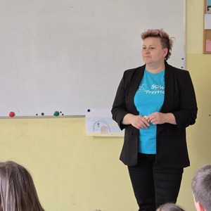 zdjęcie przedstawia pracownika socjalnego rozmawiającego z uczniami