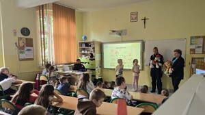 zdjęcie przedstawia policjantkę i strażnika miejskiego rozmawiającego z uczniami