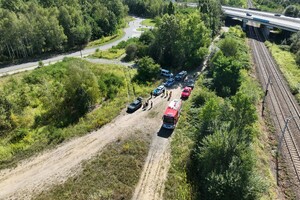 Radiowozy Policji i samochody straży pożarnej na miejscu prowadzonych ćwiczeń służb ratowniczych.