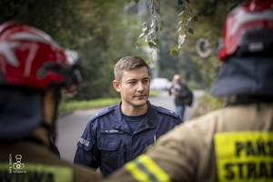 zdjęcie przedstawia policjantów i strażaków omawiających ćwiczenie