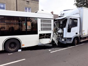 Na zdjęciu widać tył autobusu oraz kabinę ciężarówki., która jest zgnieciona po zderzeniu z autobusem