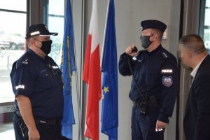 Na zdjęciu widać Komendanta Powiatowego Policji w Tarnowskich Górach młodszego inspektora Sławomira Bylickiego wraz z innym policjantem, który rozmawia przez radiostację.