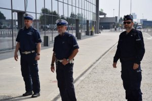 Na zdjęciu widać policjantów stojących przed portem lotniczym w Katowicach- Pyrzowicach.