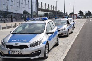 Na zdjęciu widać policyjne radiowozy znajdujące się przed portem lotniczym w Katowicach- Pyrzowicach.