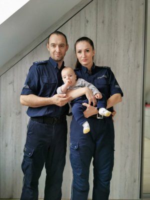 Na zdjęciu widać policjantów aspiranta sztabowego Michała Piontek oraz starszą aspirant Joannę Kmiecik-Piontek wraz z synem Aleksandrem, którego trzymają na rękach.