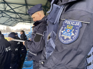 na zdjęciu naszywka na policyjnym mundurze z napisem Policja Komenda Powiatowa Policji Tarnowski Góry, w tle policjant