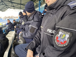 na zdjęciu naszywka na niebieskim mundurze z napisem Policji Komenda Miejska Policji w Bytomiu, w tle inni policjanci
