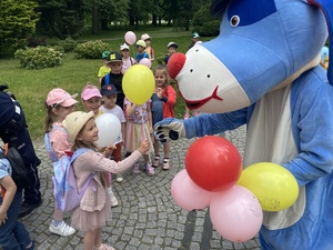 na zdjęciu sznupek rozdaje dzieciom balony