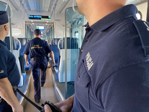 na zdjęciu dwóch policjantów i funkcjonariusz straży ochrony kolei w pociągu