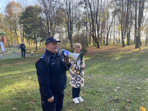 na zdjęciu komendant powiatowy z megafonem w ręku, obok dyrektor szkoły