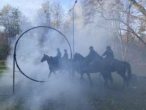 na zdjęciu policjanci na konia w dymie