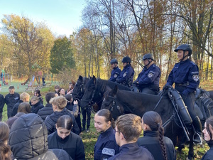 na zdjęciu młodzież przy koniach, na których siedzą policjanci