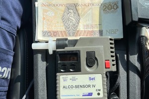 na zdjęciu urządzenie do badania trzeźwości i banknoty