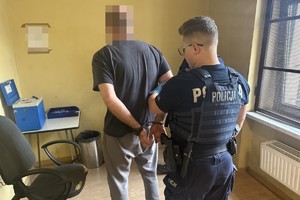 na zdjęciu policjanci z zatrzymanym w budynku komendy