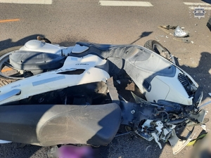 na zdjęciu leżący motocykl na jezdni z widocznymi uszkodzeniami