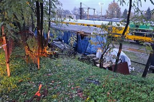 na zdjęciu samochód osobowy na dachu obok wagonu kolejowego