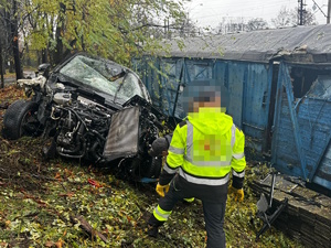 na zdjęciu rozbity samochód, przed nim mężczyzna