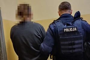 na zdjęciu policjant i zatrzymany w pomieszczeniu
