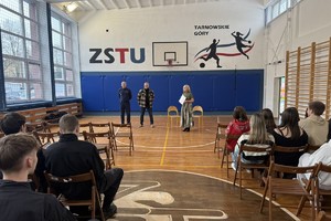 na zdjęciu aktor, policjant i nauczyciel przed uczniami w sali