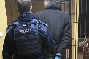 na zdjęciu policjant z zatrzymanym przed celą