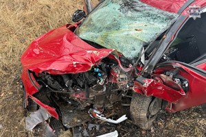 na zdjęciu rozbity przód czerwonego samochodu osobowego