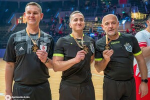 na zdjęciu trójka sędziowska, wśród której po prawej jest policjant